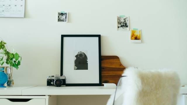 White Desk with pictures displayed on a wall