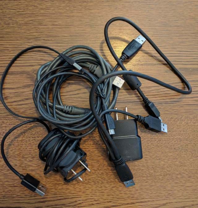A number of cables collected on a desk.