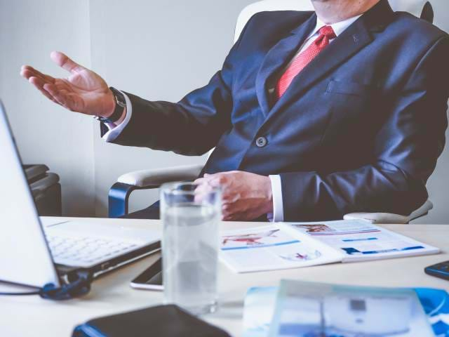 Man sitting back behind a desk with no head