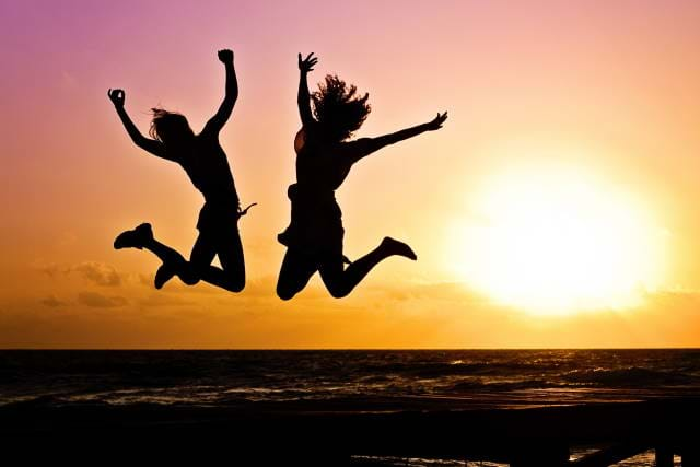 Two people jumping into the air