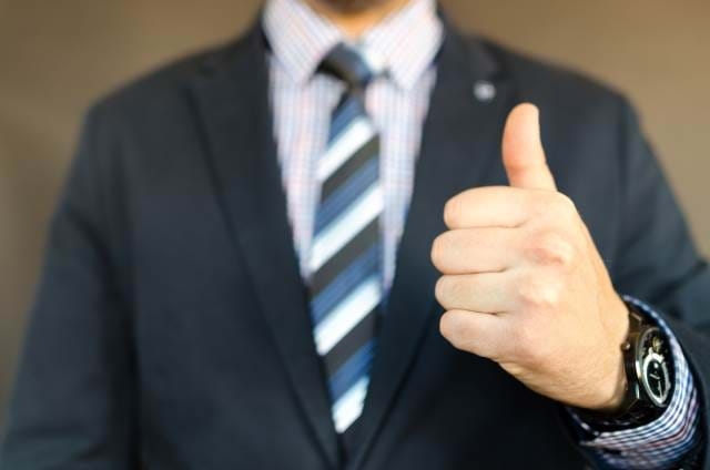 Man in a suit giving the thumbs-up