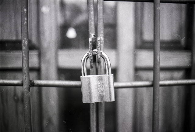Azure Security using MFA is critical for web applications Black and White picture of padlock on a fence