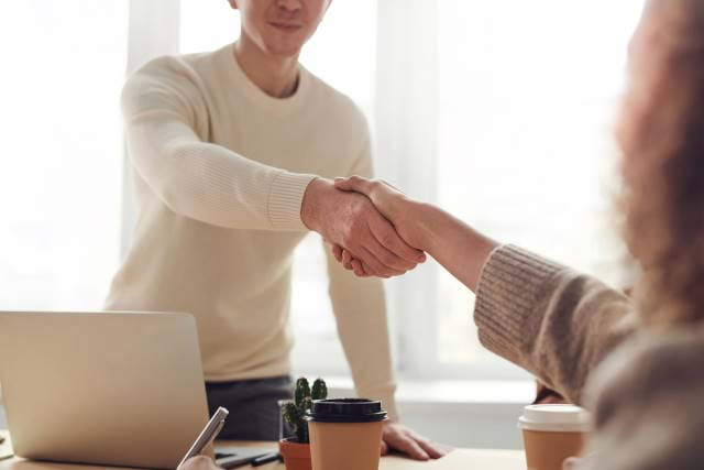 Man shaking hands in agreement with a woman