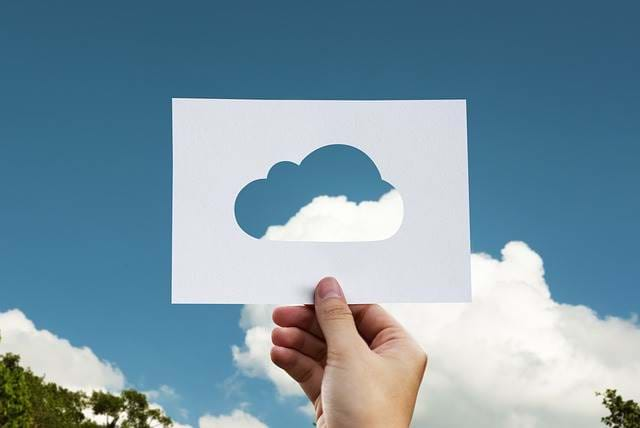 Man holding up a template of a cloud to the sky