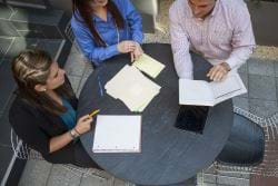 Three People around a table discussing guidelines