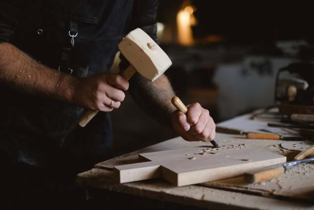 Man using a hammer to hit wood