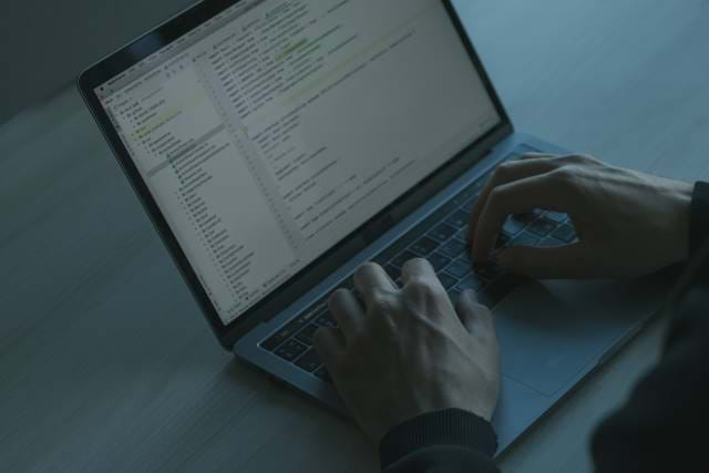 Laptop with hands on keyboard on a desk