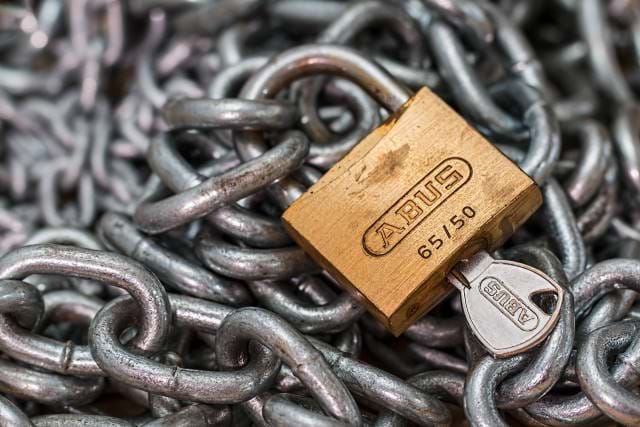 Padlock with key surrounded by chains