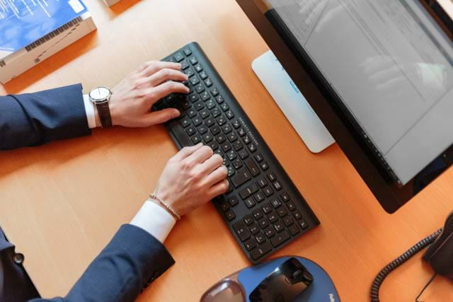 Man with hands on a keyboard with screen visible in a top-down view