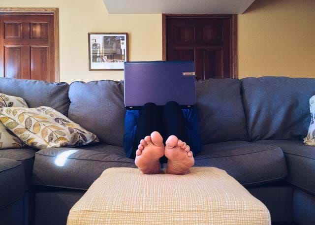Person sitting on a couch with a laptop