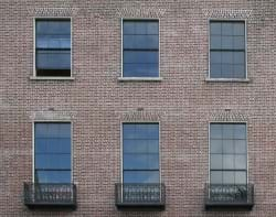 A grouping of windows on a brick wall